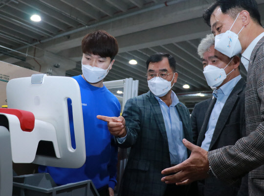 강신호(왼쪽 두번째) CJ대한통운 대표이사와  주요 경영진들이 경기도 동탄 소재 TES 이노베이션 센터에서 '자율주행 이송로봇(AMR)'을 기반으로 한 '오더피킹 시스템' 시연을 보고 있다. <CJ대한통운 제공>